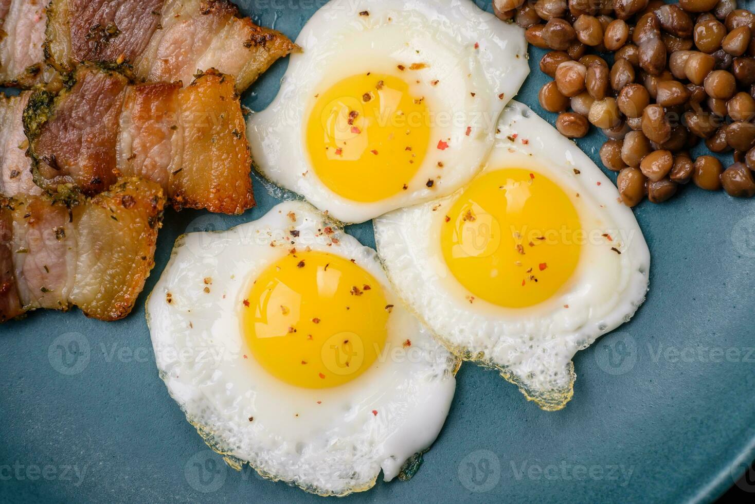 köstlich nahrhaft Frühstück von gebraten Wachtel Eier, Speck, Hülsenfrüchte und Kirsche Tomaten foto