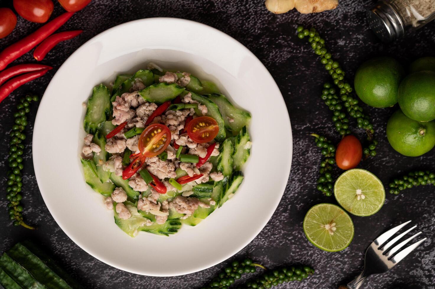 gebratene Zucchini mit Schweinehackfleisch in weißem Teller rühren foto