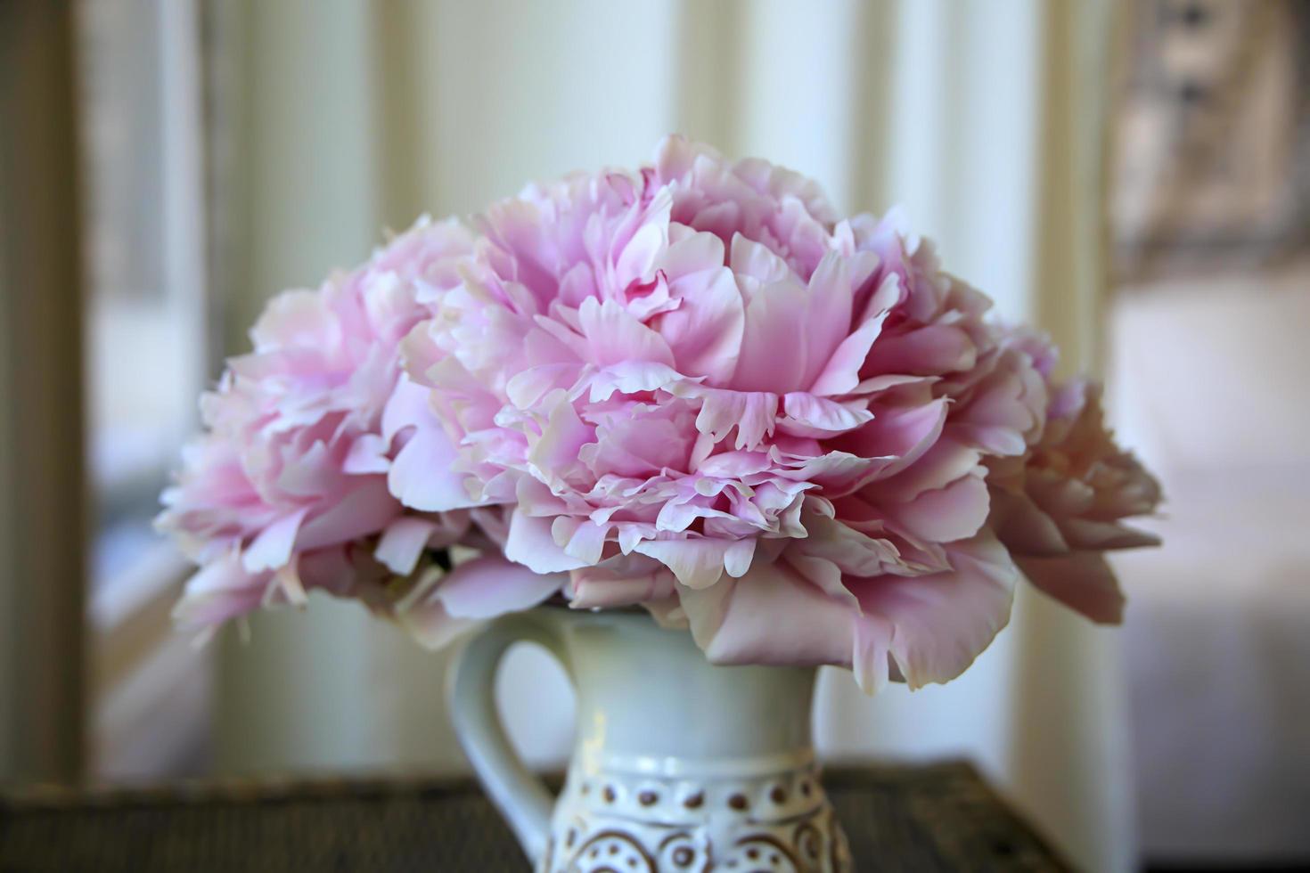 blühende rosa Blume in einer Vase auf einer Veranda foto