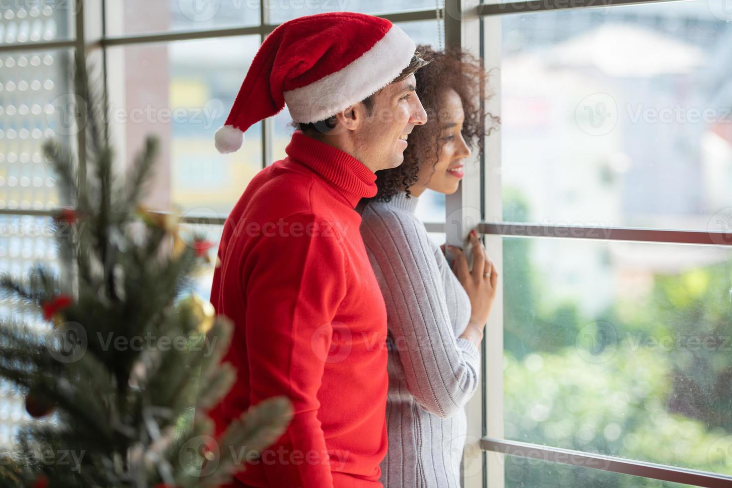 Paare im Wohnzimmer während Frohe Weihnachten und ein gutes neues Jahr foto