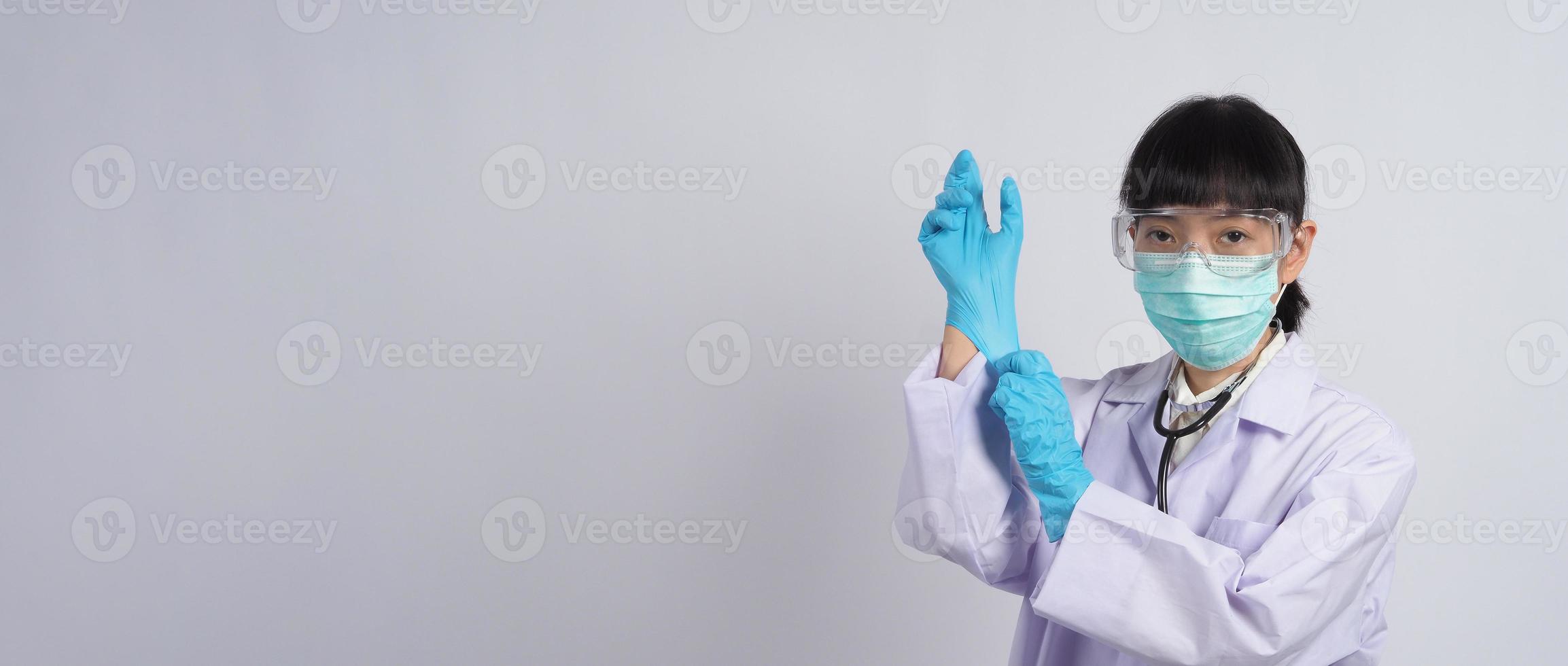 Handschuhe tragen. asiatischer Arzt trägt blauen Nitril-Gummihandschuh. foto