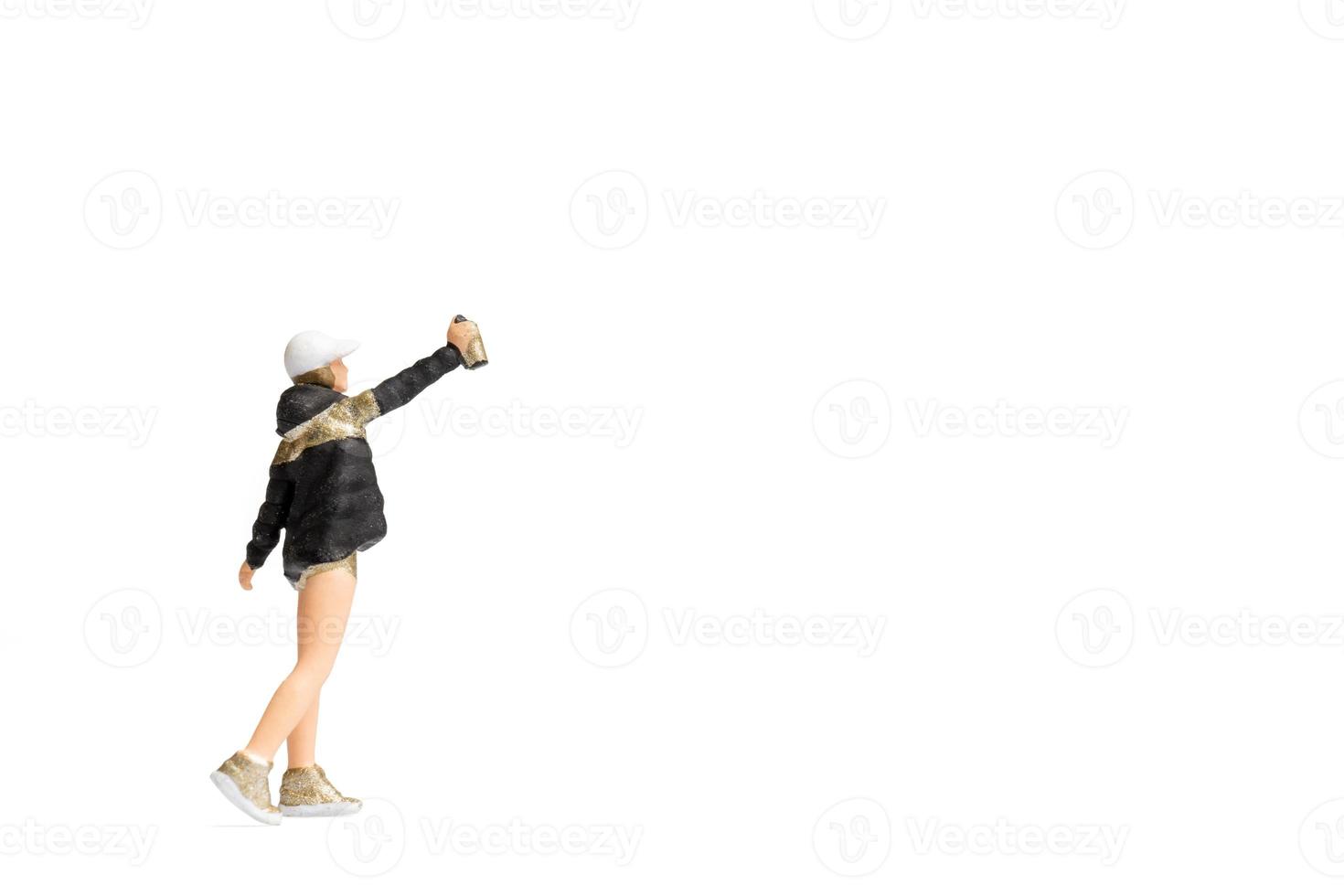 Miniaturmenschen Teenager, die Farbe aus der Dose auf weißem Hintergrund sprühen foto