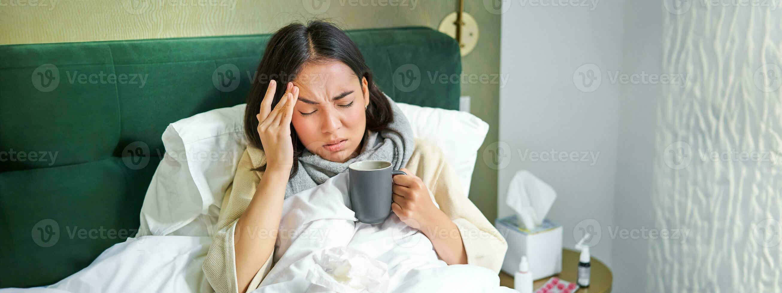 Grippe, Krankheit und Personen. jung Frau Gefühl krank, haben Fieber und fangen col, Lügen im Bett mit heiß Tee, nehmen Drogen von Grippe foto