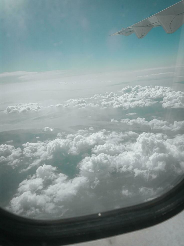 Himmel und Wolken von Flugzeug Flügel wie gesehen durch Fenster von ein Flugzeug foto