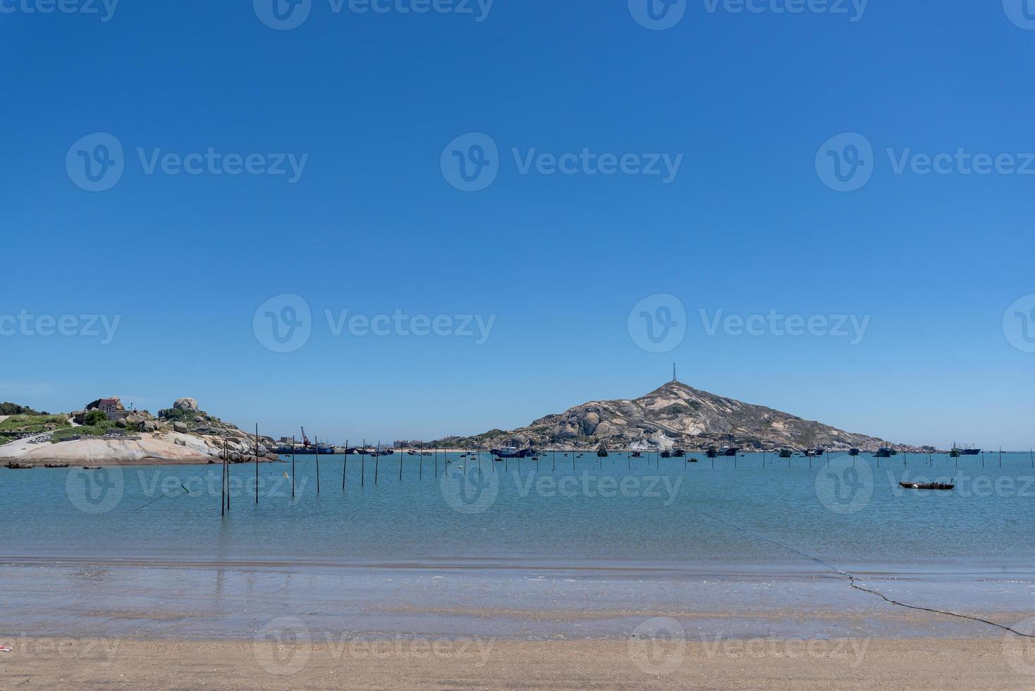 das Meer unter blauem Himmel, saubere Strände und Meerwasser sowie Inseln und Windmühlen foto