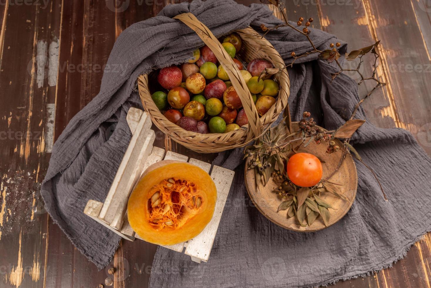 Kürbisse und viele andere Farben und Sorten von Obst und Gemüse stehen auf dem Holzmasertisch foto