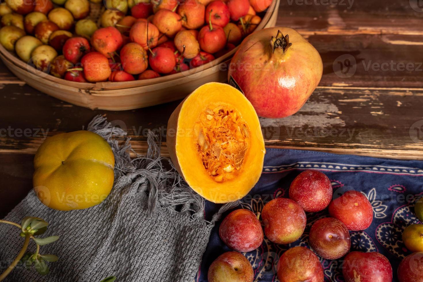 Kürbisse und viele andere Farben und Sorten von Obst und Gemüse stehen auf dem Holzmasertisch foto