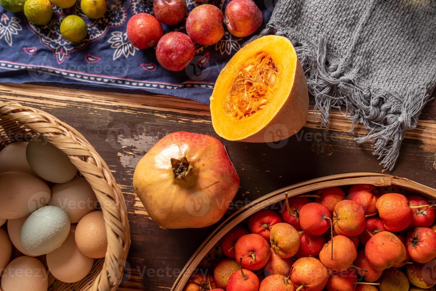 Kürbisse und viele andere Farben und Sorten von Obst und Gemüse stehen auf dem Holzmasertisch foto