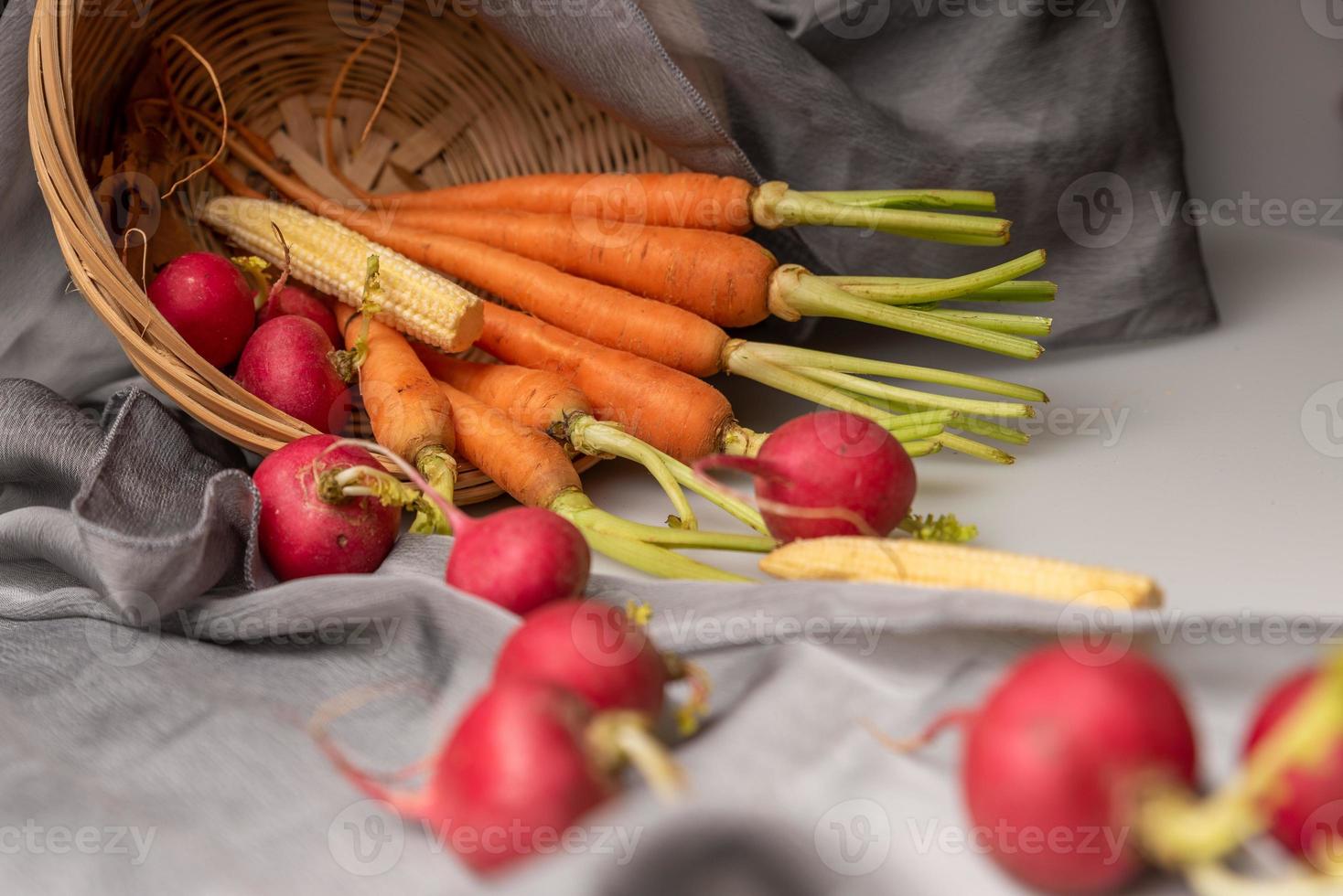 die roten und orangen Radieschen sind auf dem weißen Tuch foto