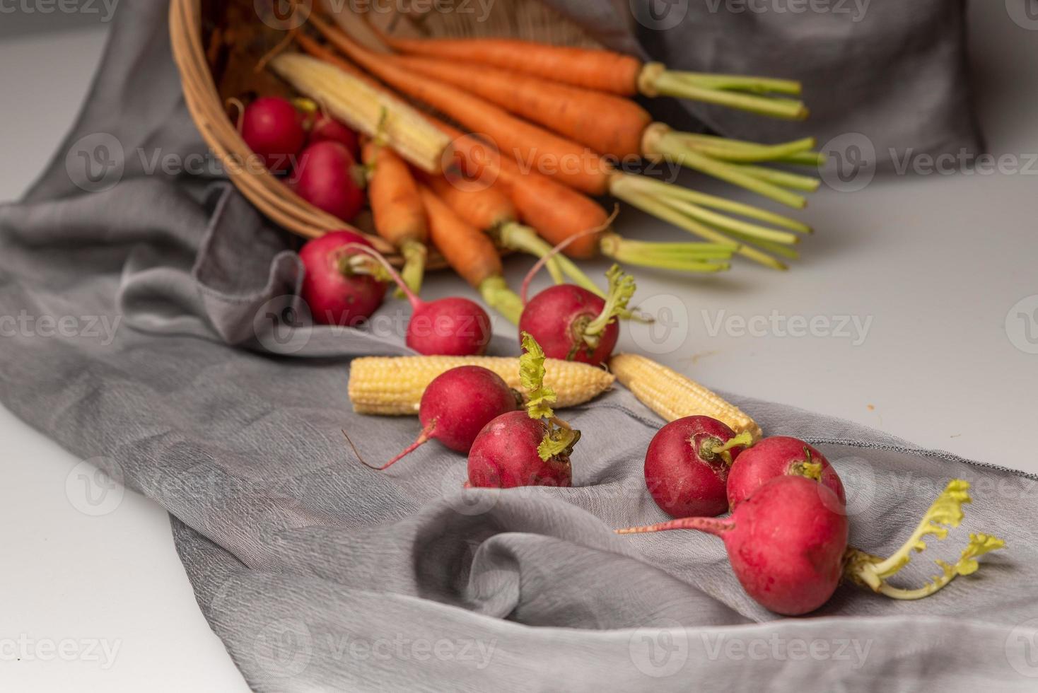 die roten und orangen Radieschen sind auf dem weißen Tuch foto