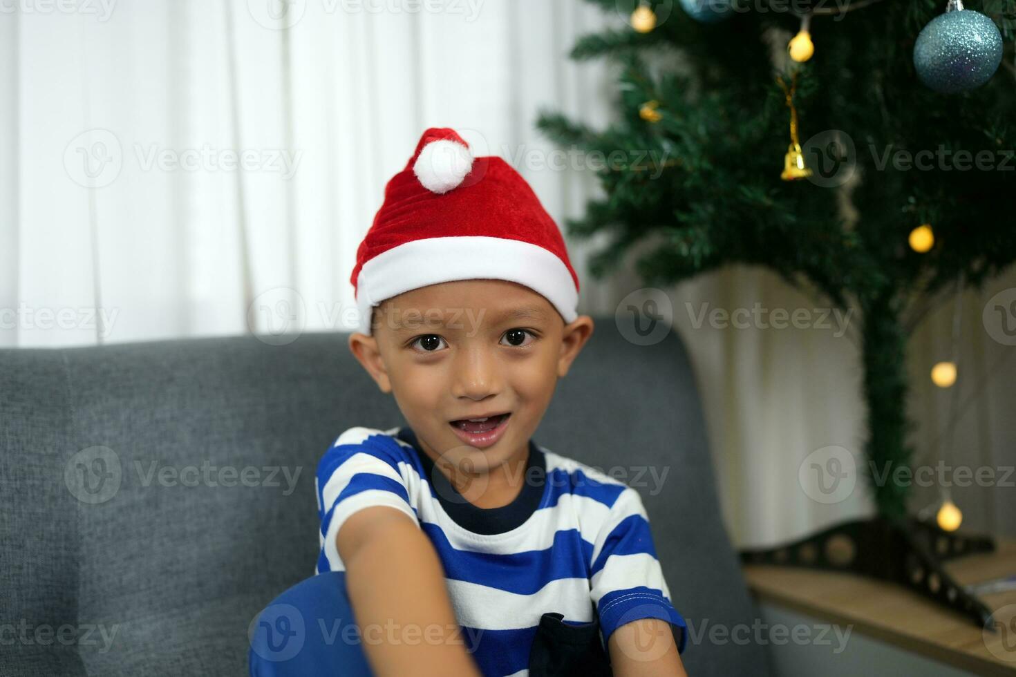 fröhlich Weihnachten 2024 Konzept asiatisch Junge dekoriert Weihnachten Baum mit bunt Weihnachten Bälle. foto