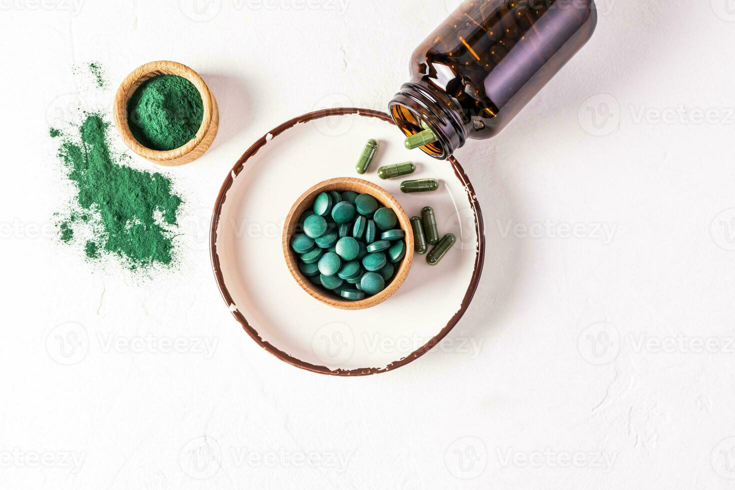 runden Blau Grün natürlich Spirulina Algen Tablets und Pulver im Schüssel auf Weiß Hintergrund. medizinisch Krug mit Seetang Kapseln. natürlich Essen Ergänzungen. foto