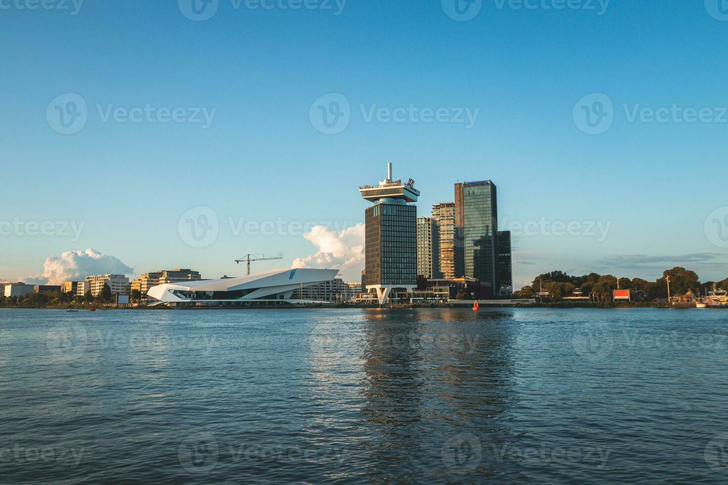 Main Tourist Center im amsterdam, das Niederlande, ein Aussicht von das ganze Stadt auf das andere Seite von das Kanal während Sonnenuntergang foto