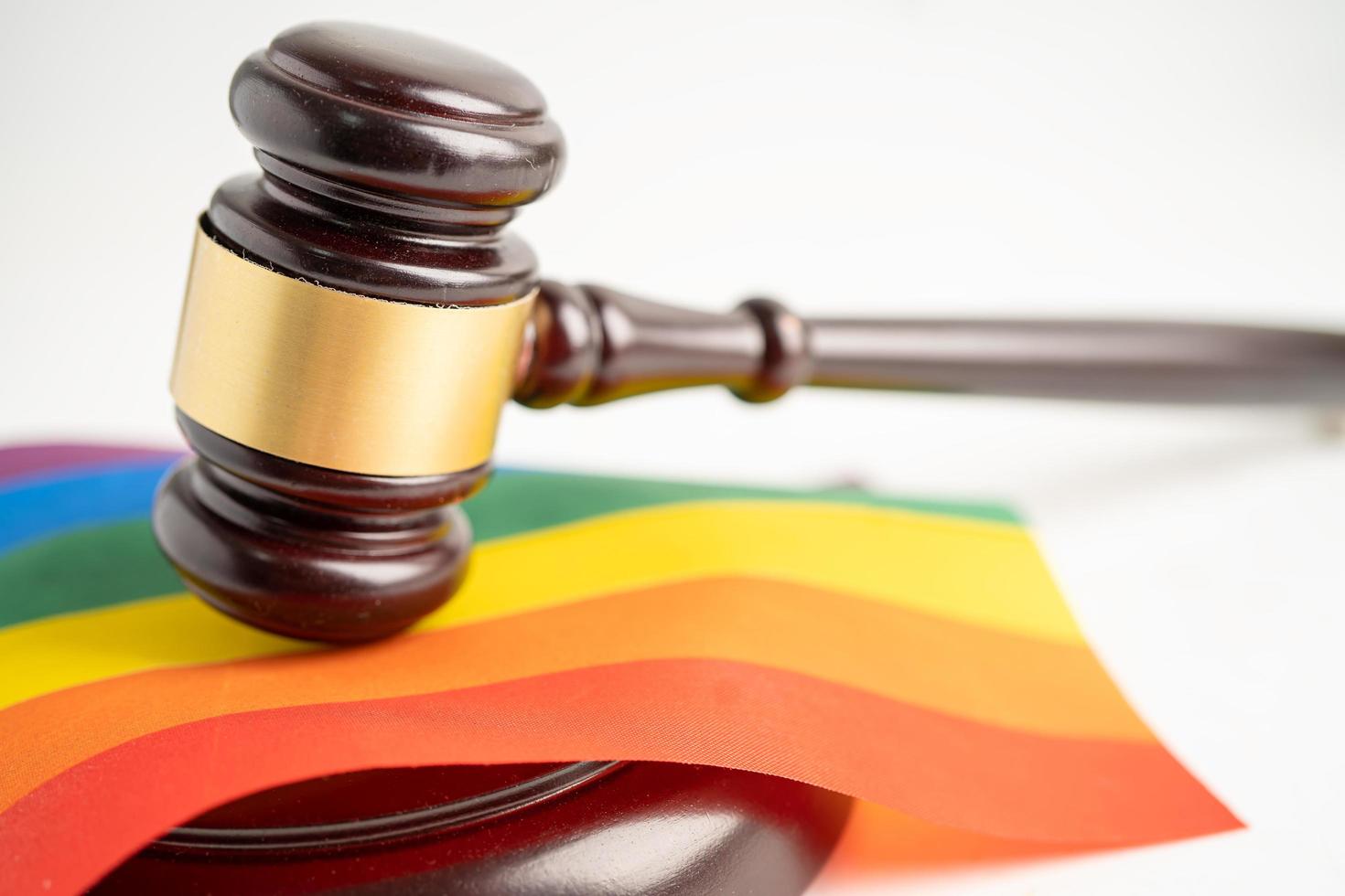 Hammer für Richter Anwalt auf Regenbogenfahne, Symbol des LGBT-Stolzmonats, feiern jährlich im Juni soziale von Schwulen, Lesben, Bisexuellen, Transgender, Menschenrechten foto