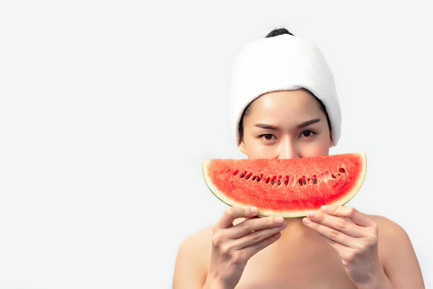asiatische Schönheitsfrau, die Wassermelone auf weißem Hintergrund hält. Schönheits- und Modekonzept. Thema Medizin und Gesundheit. Menschen Lifestyle-Porträt. Speisen- und Getränkekonzept foto