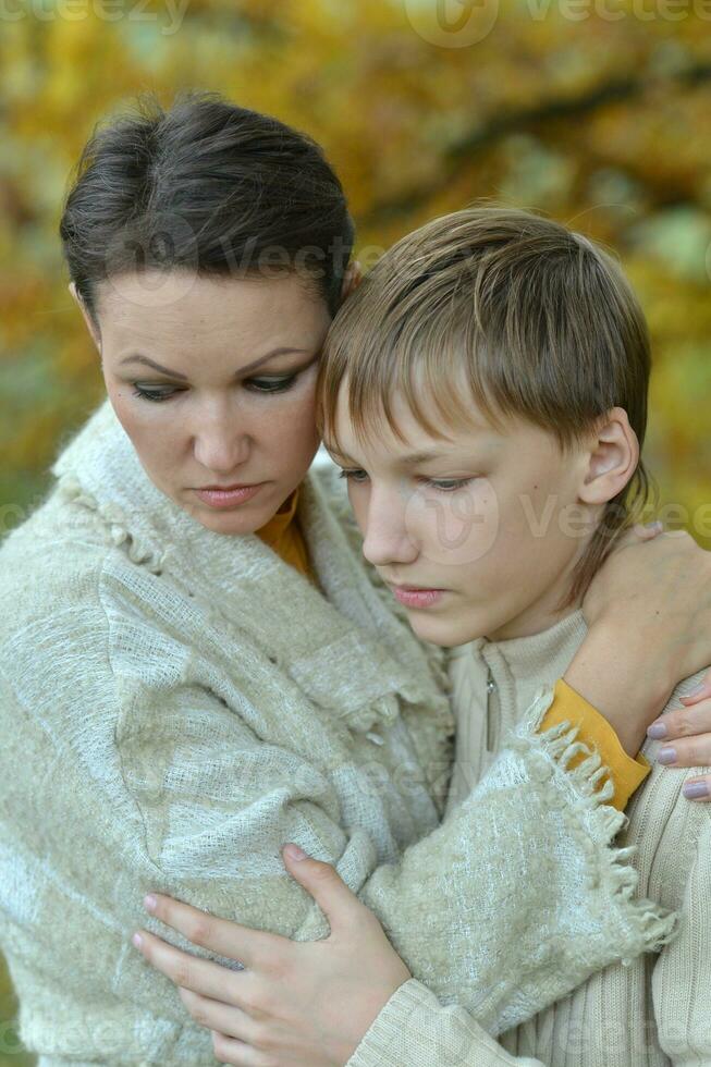 traurig Mutter mit Sohn auf ein gehen im Park foto