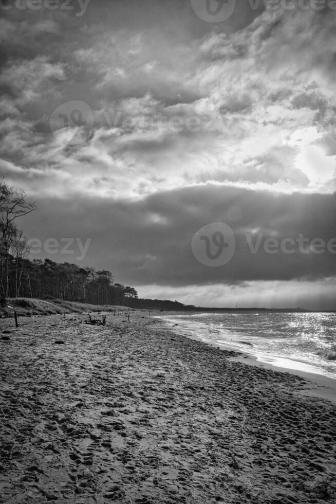 Sonnenuntergang auf das Westen Strand auf das baltisch Meer. Wellen, Strand, wolkig Himmel und Sonnenschein foto