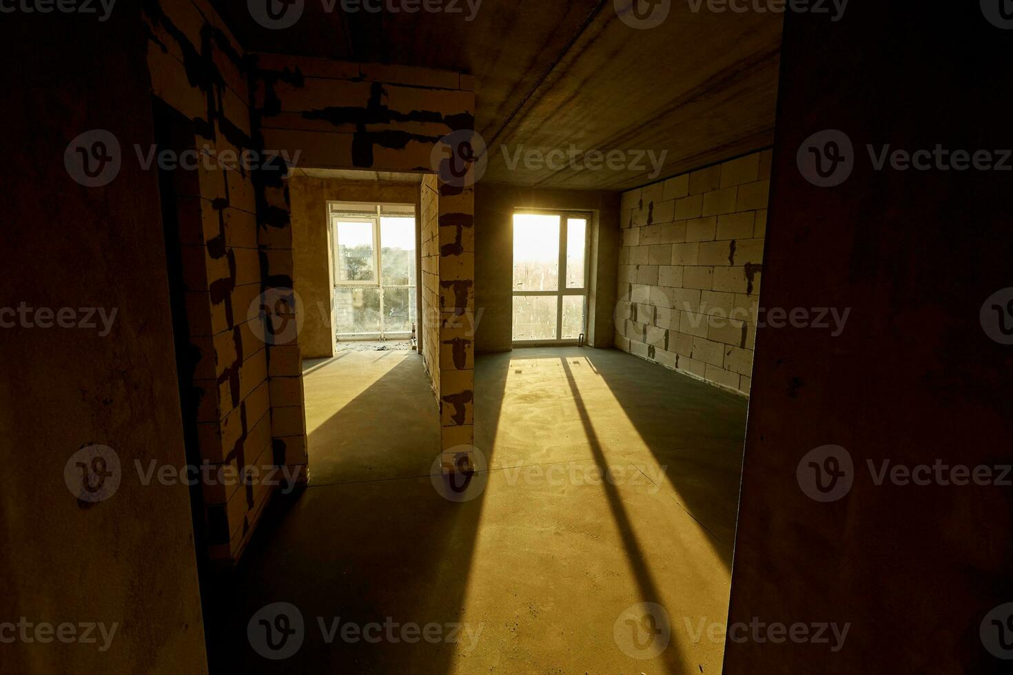 unvollendet leeren Wohnung, zwei enorm Plastik Fenster, Wände gemacht von belüftet Beton Blöcke, Zement Estrich auf das Boden. Gebäude unter Konstruktion foto