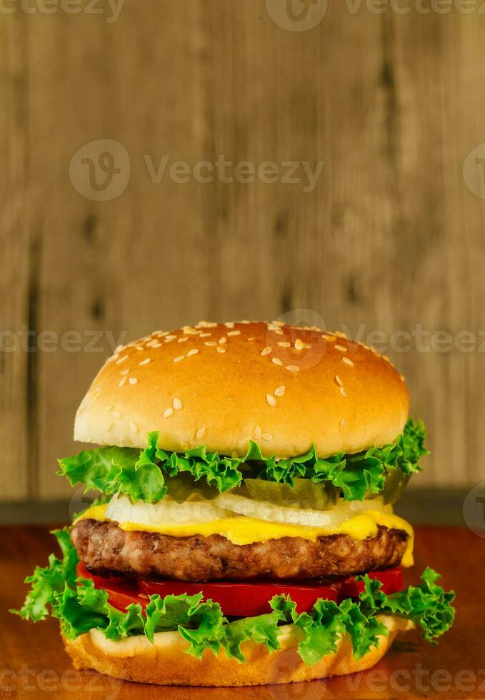 klassisch Deluxe Cheeseburger mit Kopfsalat, Zwiebeln, Tomate und Gurken foto