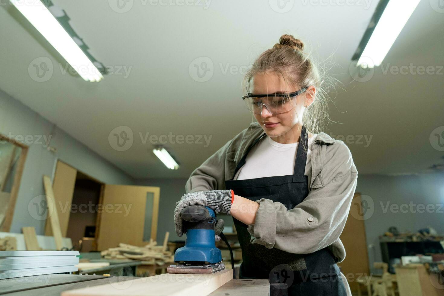 ein jung weiblich Zimmermann Arbeiten Projekt im ihr Werkstatt. weiblich Zimmermann Herstellung hölzern Möbel. foto