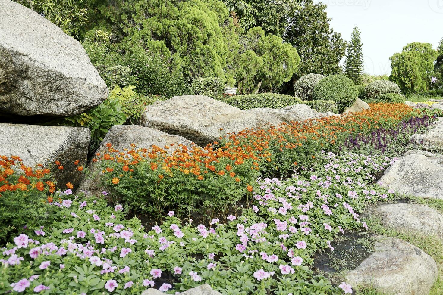 szenisch Aussicht von ein schön Blume Stil Landschaft Garten mit ein Grün gemäht Rasen und bunt Blume Bett mit selektiv Fokus foto