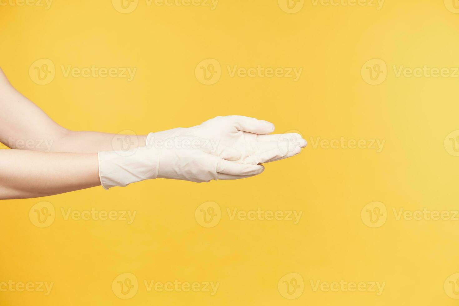 Seite Aussicht von jung Frau Hände gekleidet im Weiß Gummi Handschuhe behalten Palmen oben während gehen zu waschen Hände, Sein isoliert gegen Orange Hintergrund foto