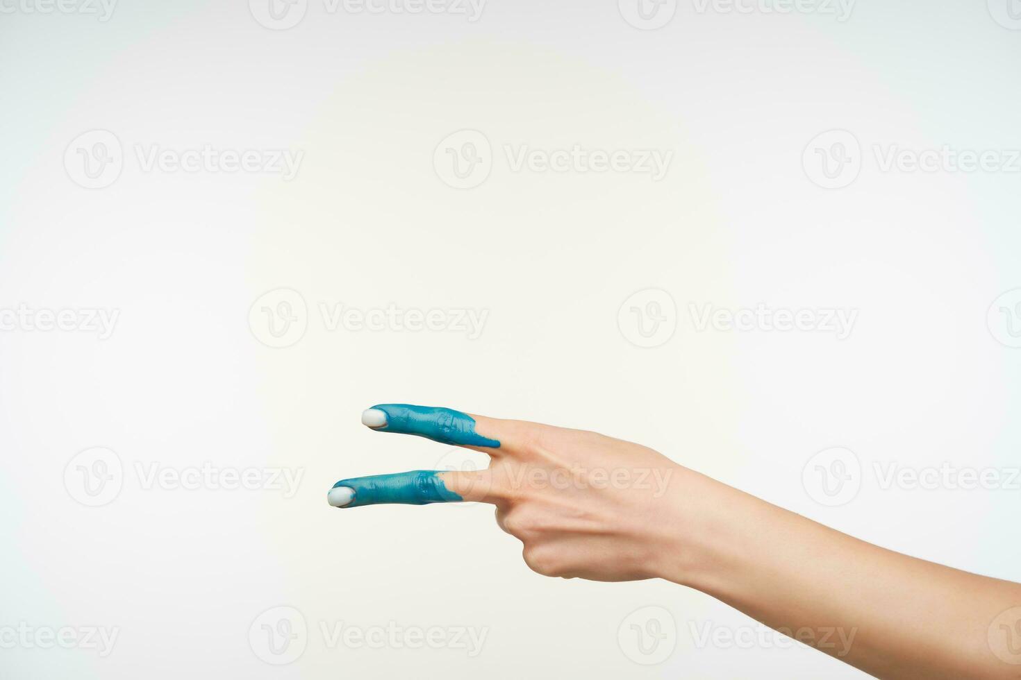 Seite Aussicht von elegant Damen- Hand mit Blau Farbe auf es Bildung Frieden Geste mit zwei Finger während posieren Über Weiß Hintergrund. Hand Zeichen und gestikulieren Konzept foto
