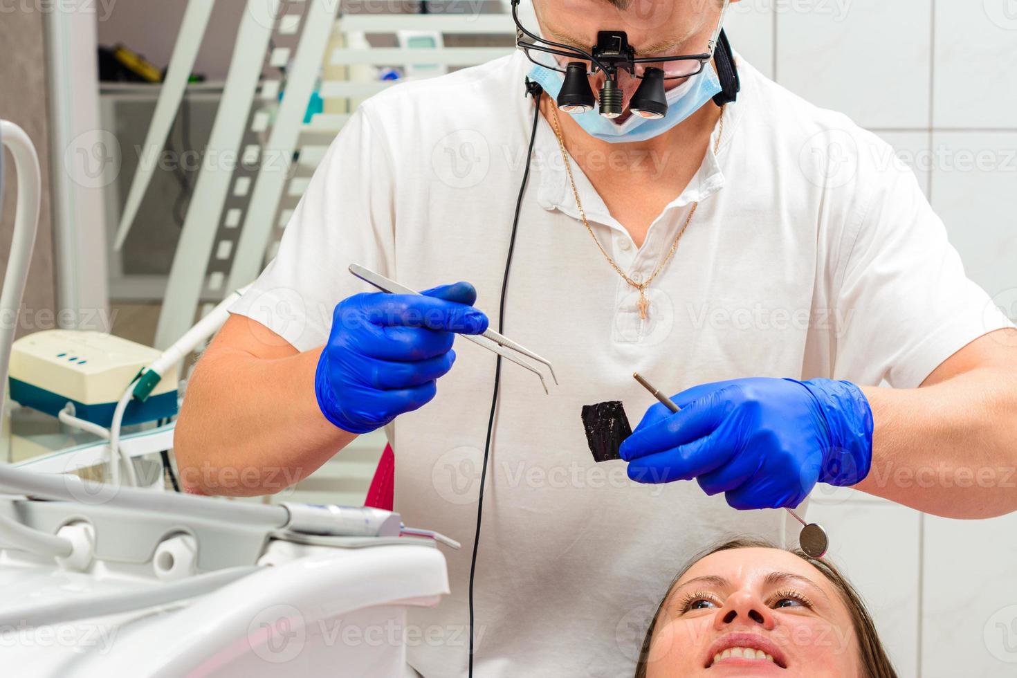 der Zahnarzt entfernt das überschüssige Material vom Zahn foto