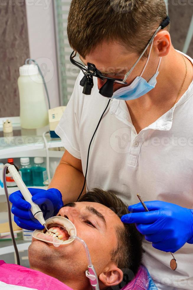 der Zahnarzt verwendet ein Fernglas für das beste Ergebnis und die beste Arbeit foto
