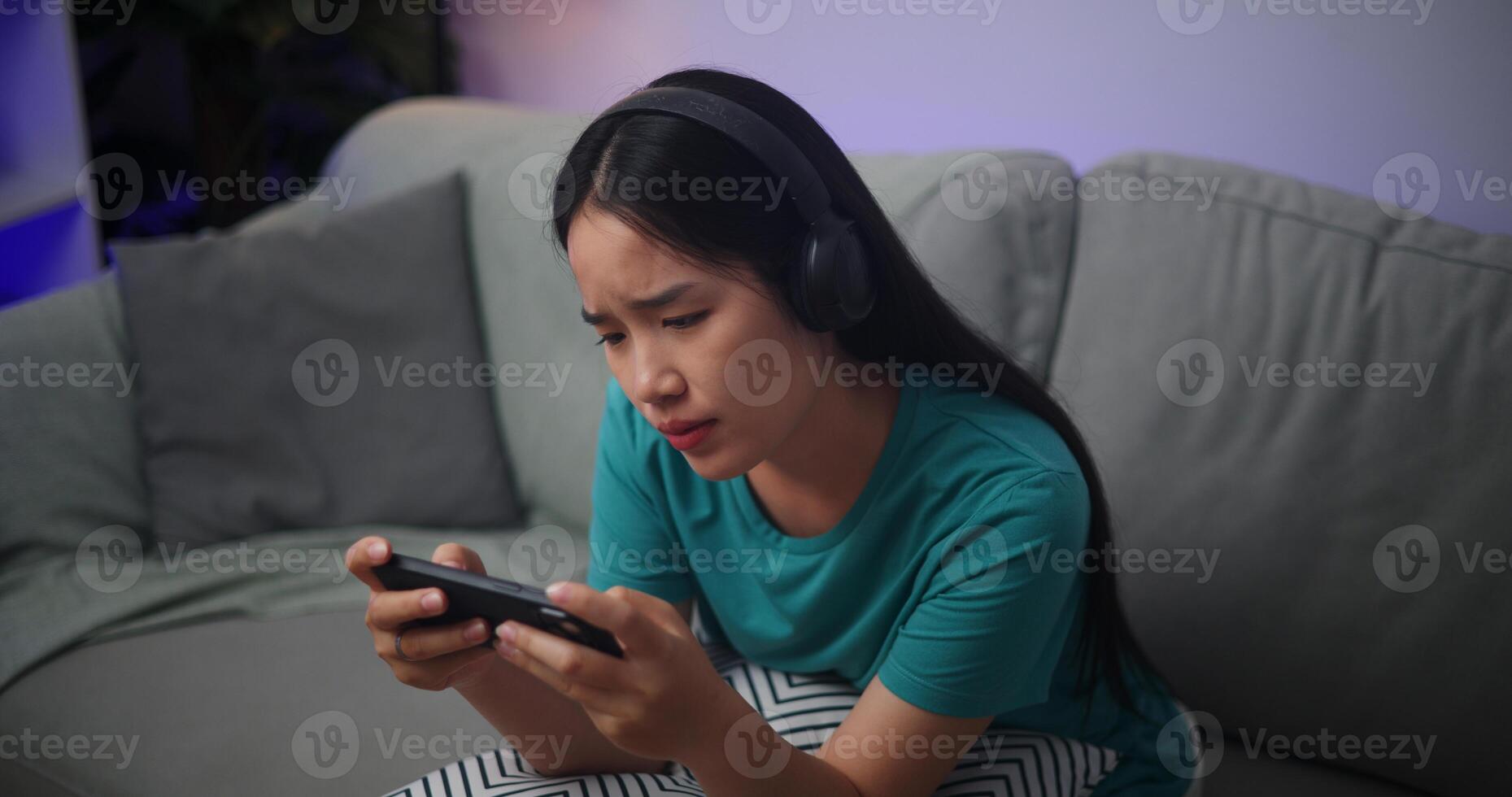 Porträt von jung asiatisch Frau ernst spielen ein online Spiel frustriert mit Verlust oder Fehler Sitzung auf Sofa im Leben Zimmer beim home.gamer Lebensstil Konzept. foto