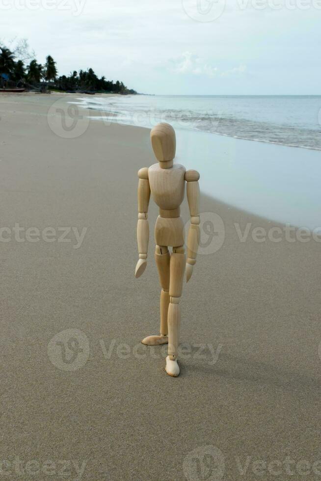 hölzern Modelle Gefühl einsam auf das Strand. foto