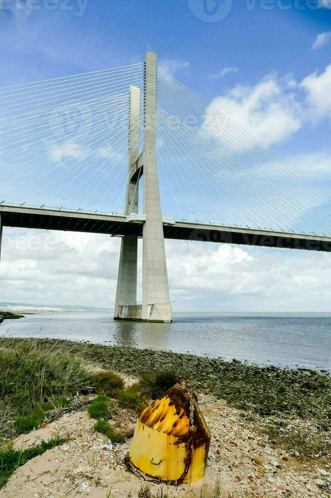 das Brücke ist Über das Wasser und hat ein Gelb Pole foto