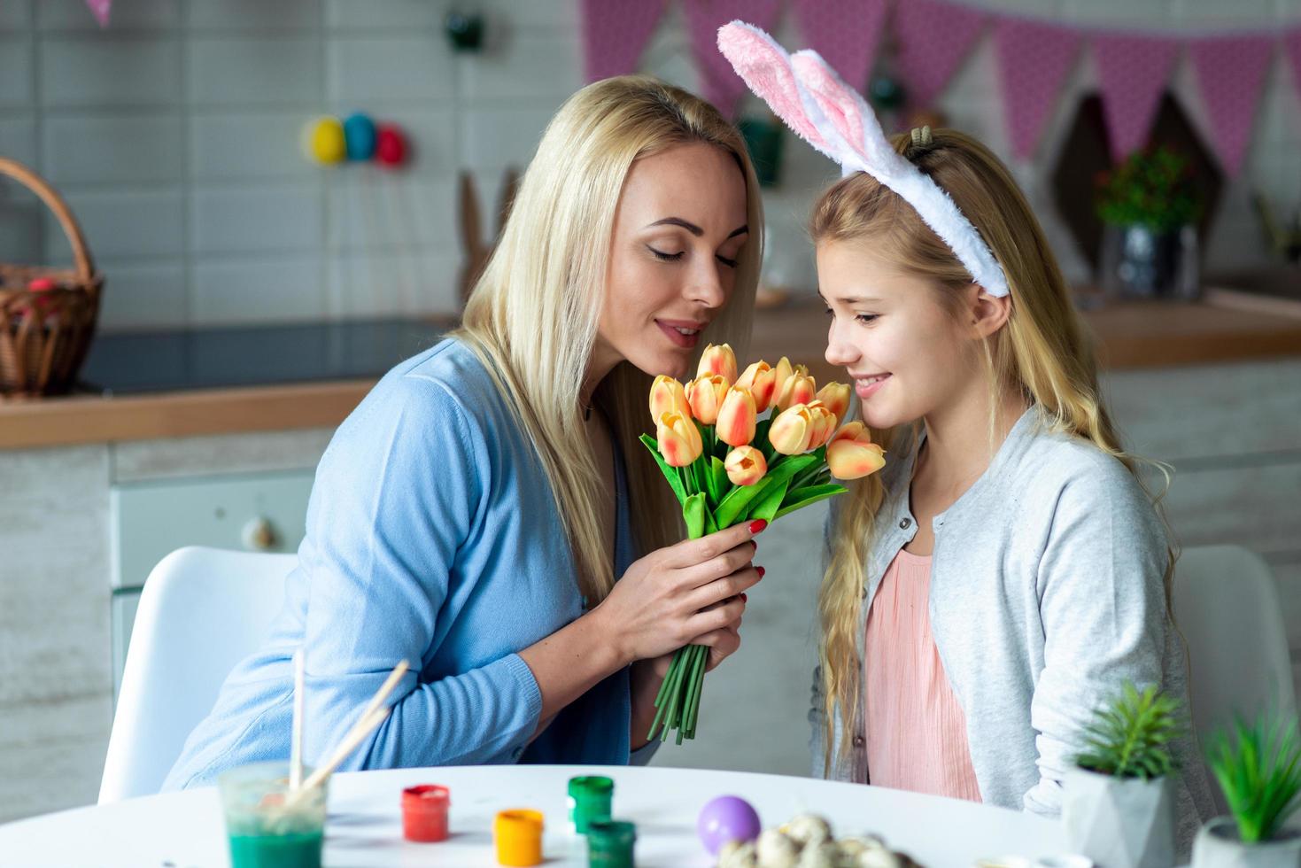 mutter und ihre tochter schnuppern an tulpen foto