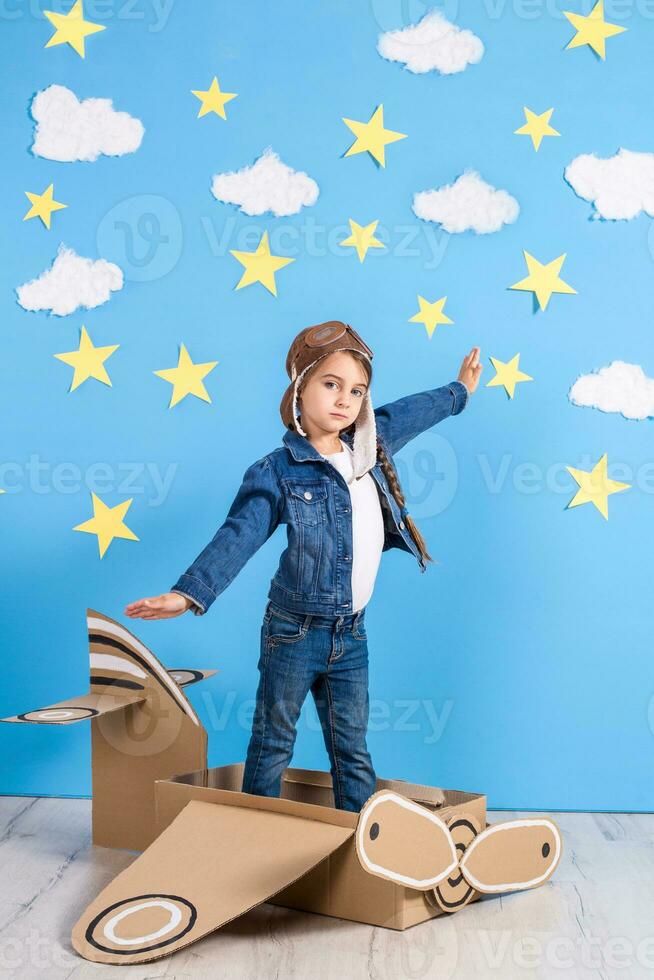 wenig Kind Mädchen im ein Piloten Kostüm ist spielen und träumend von fliegend Über das Wolken. foto