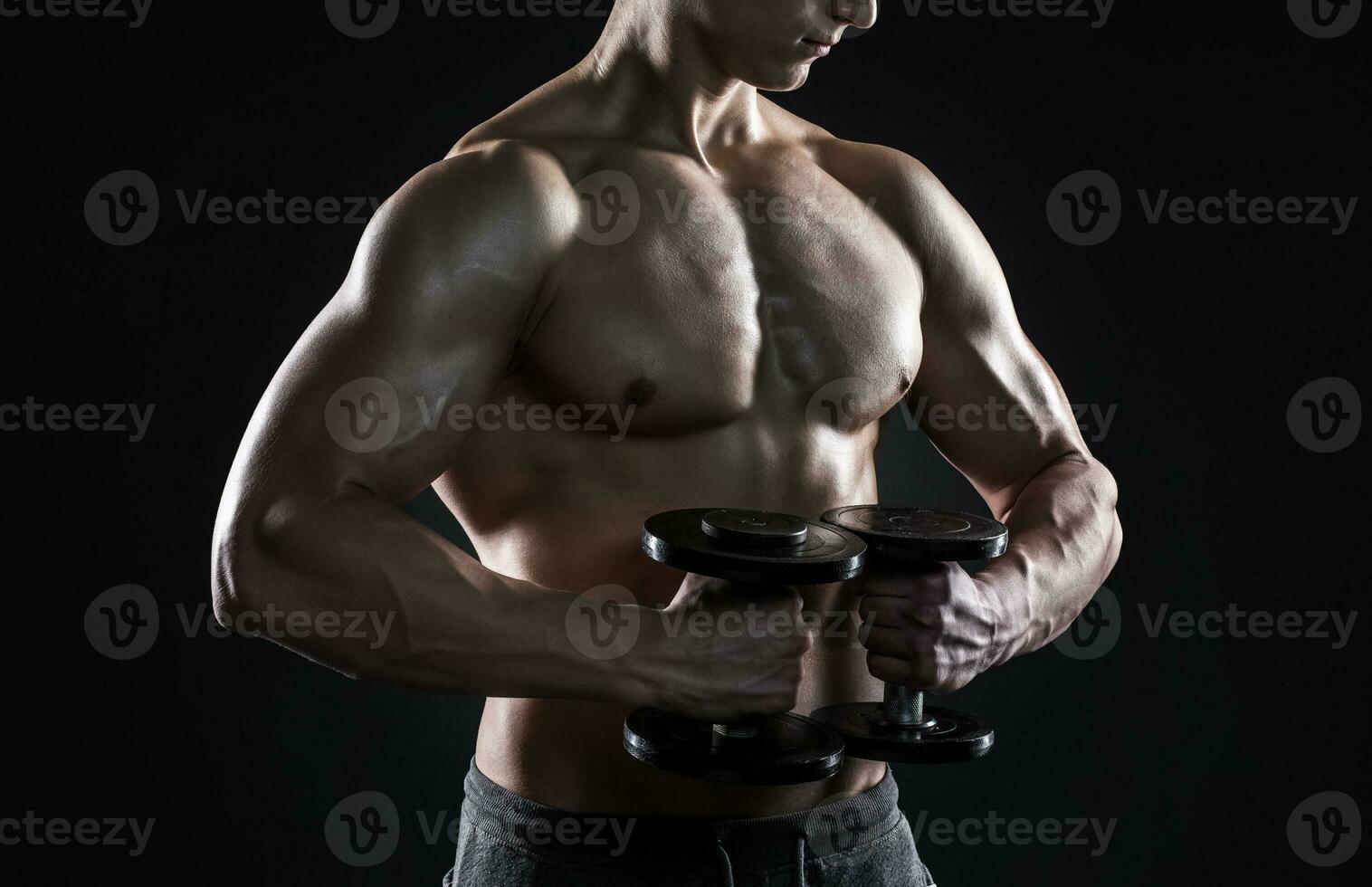 mächtig Fitness Mann zeigen seine großartig Körper mit Hanteln foto