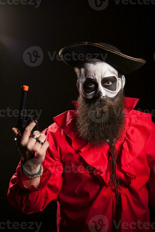 verrückt und gespenstisch mittelalterlich Pirat mit seine Pistole Über schwarz Hintergrund. Halloween Outfit. foto