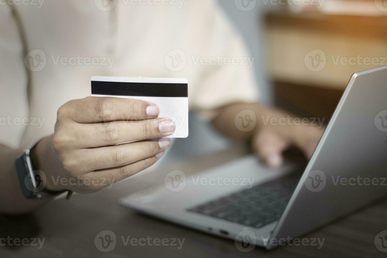 Nahansicht von des Mannes Hand bezahlen online mit Anerkennung Karte, online Einkaufen auf Laptop beim heim, online Transaktion foto