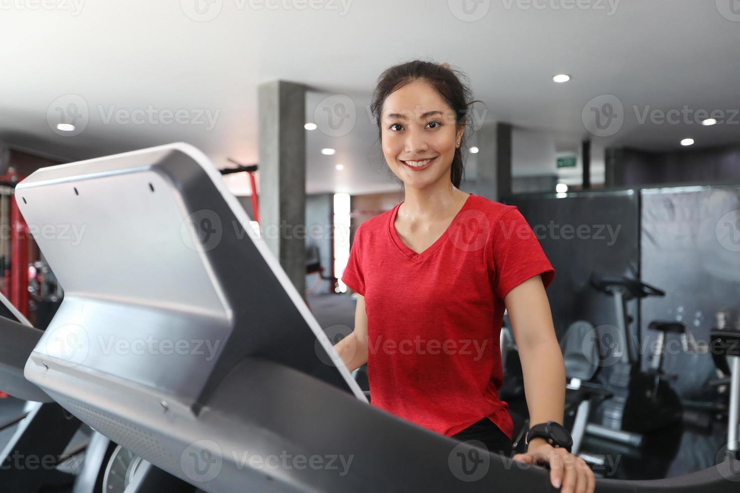 Asiatische Frauen, die Sportschuhe im Fitnessstudio laufen lassen, während eine junge Kaukasierin auf dem Laufband joggt foto