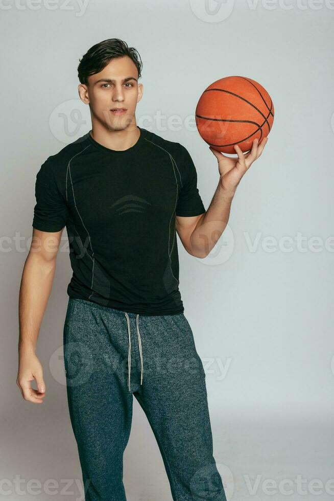 gut aussehend jung lächelnd Mann Tragen ein Basketball Ball foto