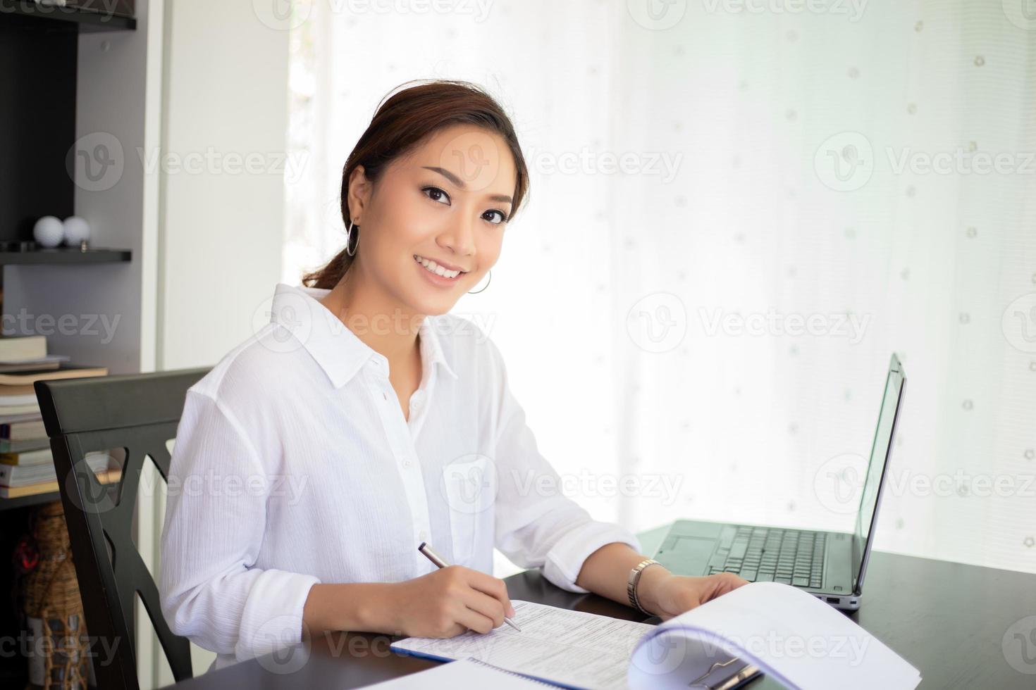 Asiatische Geschäftsfrauen, die Notebook verwenden und glücklich für die Arbeit lächeln foto