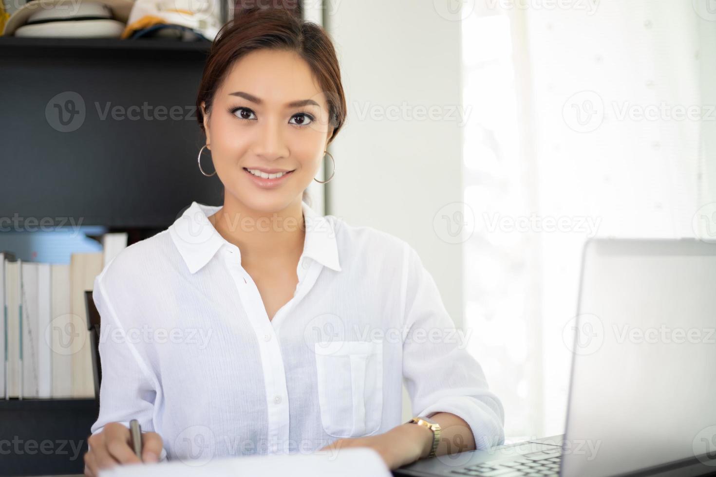 Asiatische Geschäftsfrauen, die Notebook verwenden und glücklich für die Arbeit lächeln foto