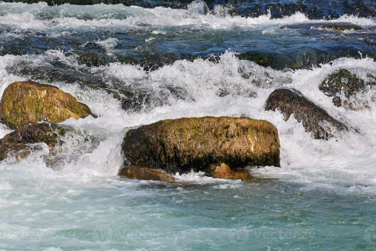 ein Fluss mit Felsen und Wasser eilen Über Sie foto