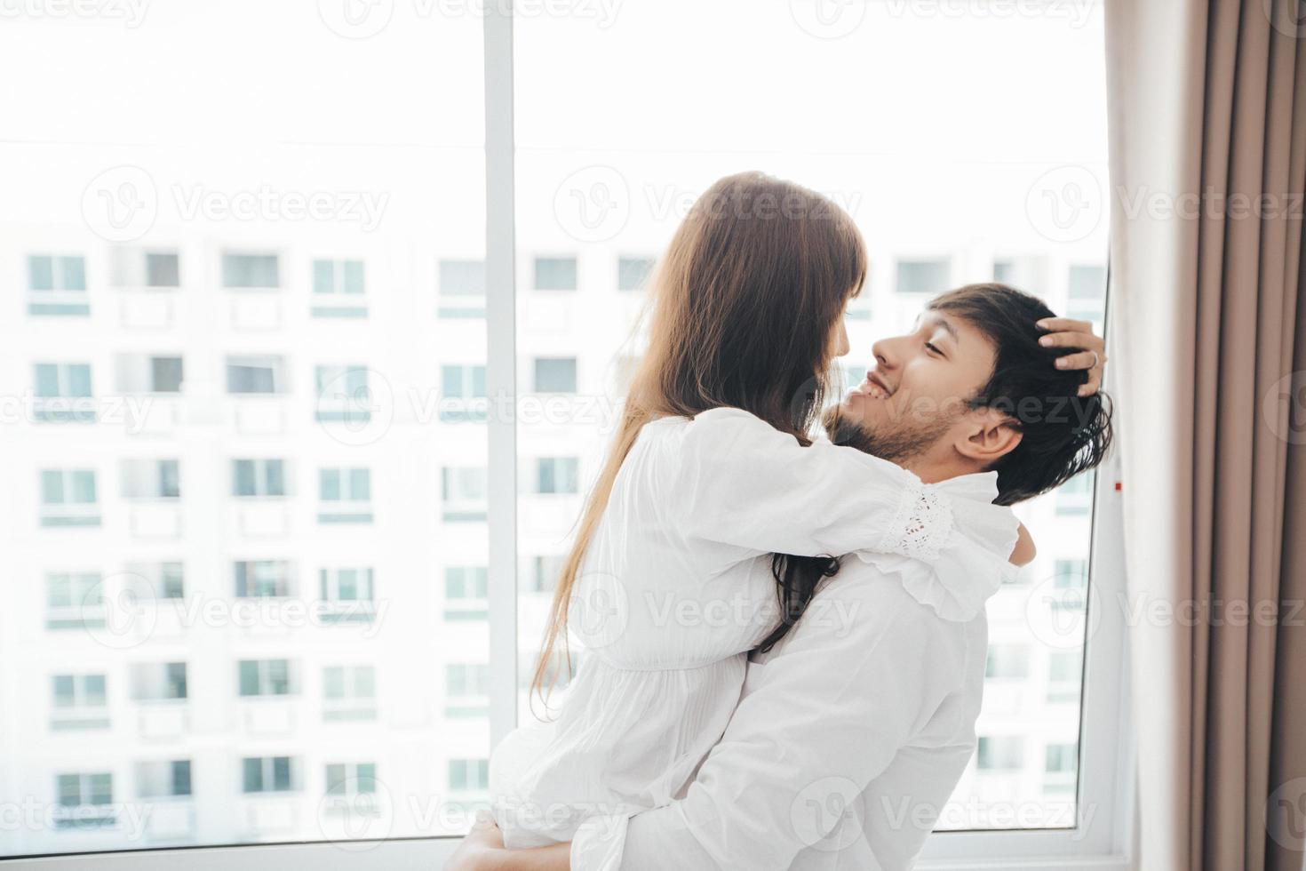 Paarliebhaber, der auf dem Bett Glückslebensstil legt und lächelndes Mädchen im weißen Bett entspannt foto