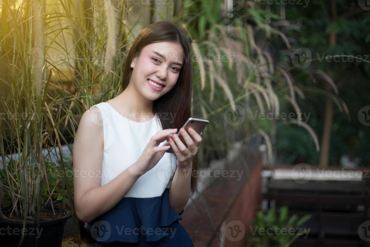 asiatische Frauen lächeln und verwenden Handy und Touch-Smartphone für die Kommunikation und überprüfen Geschäftsleute im Freien im Café foto