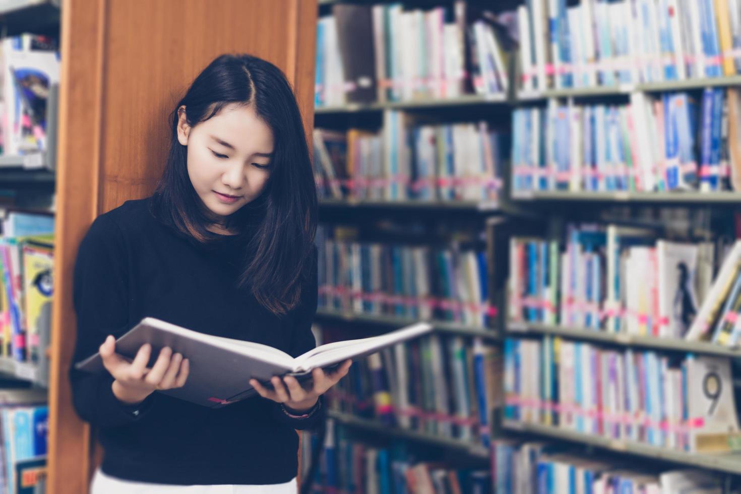 asiatische Studenten, die Bücher in der Bibliothek lesen. foto