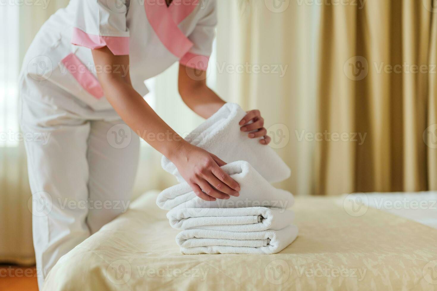 schließen oben Bild von Hotel Maid Putten frisch und sauber Handtücher auf Bett. foto