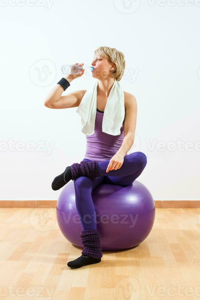 Frau Trinken Wasser nach Übung foto