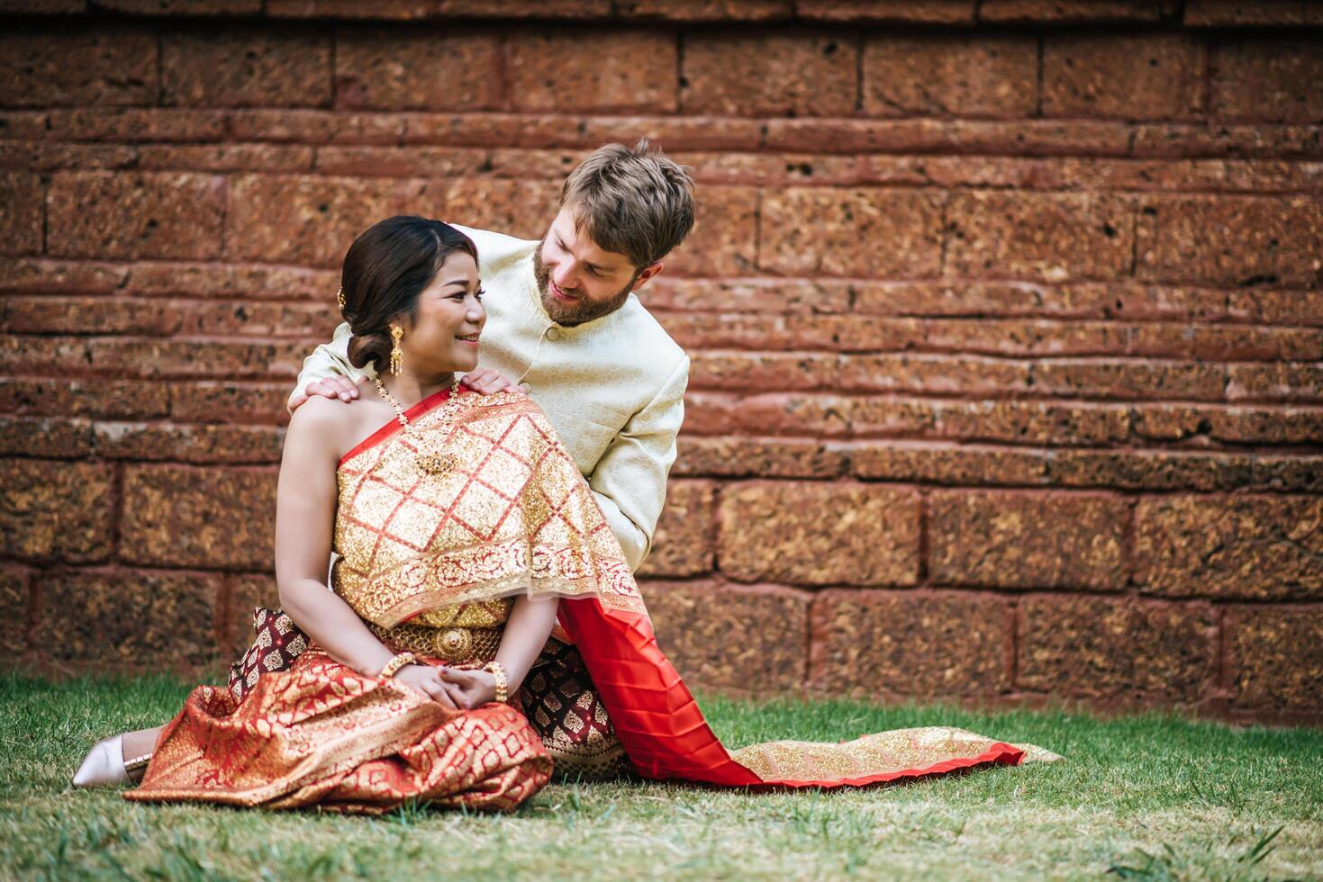 asiatische braut und kaukasischer bräutigam haben romantische zeit mit thailandkleid foto