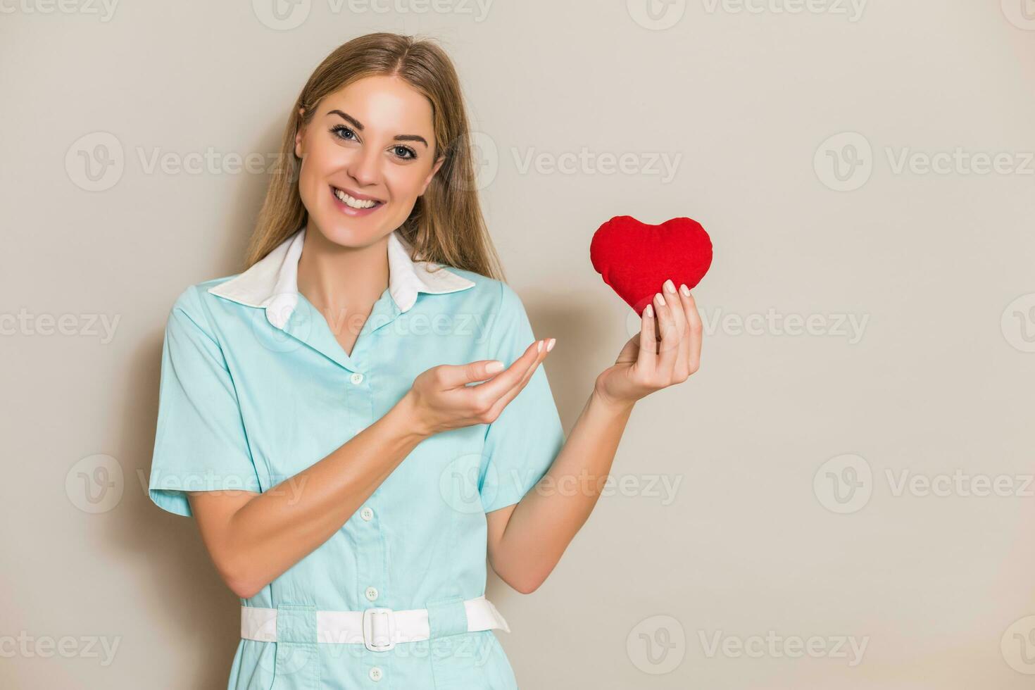 Porträt von medizinisch Krankenschwester halten rot Herz. foto