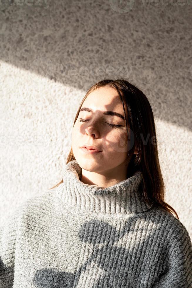 Porträt einer schönen jungen Frau mit einem Schattenmuster auf Gesicht und Körper in Form von Baumwolle foto